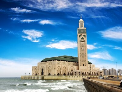 Hassan II Mosque in Casablanca with rolling waves crashing in foreground, Morocco, Africa